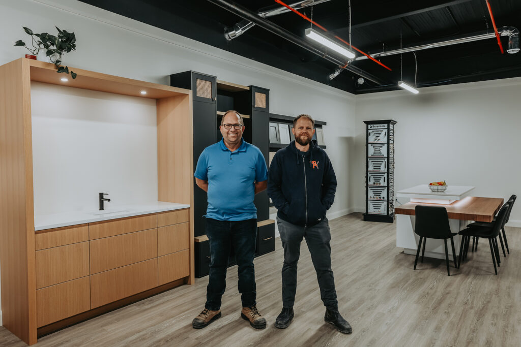 Dan and Bill from Clear Solutions Inc. in Aylmer, Ontario standing in a showroom showcasing kitchen and bathroom cabinets.